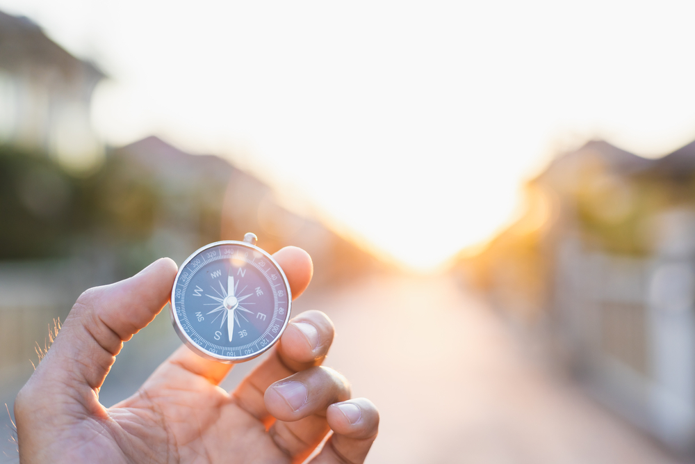 man-holding-compass-on-blurred-background-for-activity-lifestyl